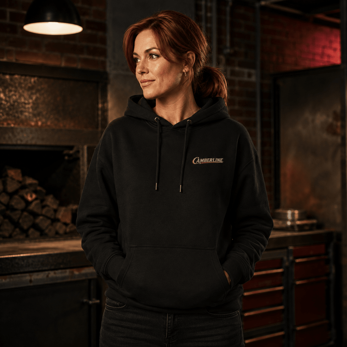 Front view of model wearing the black Camberline hoodie with chest logo
