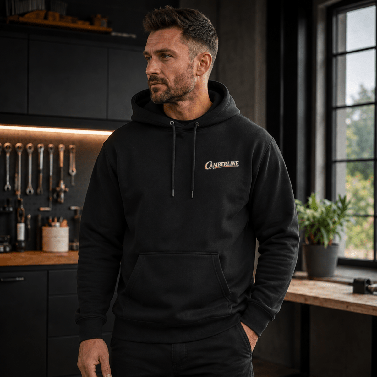 Front view of model wearing the black Camberline hoodie with chest logo