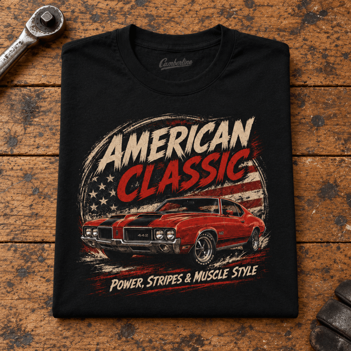 Camberline American Classic 1970s Red Sports Coupe Graphic T-Shirt in black, folded front view on a workshop bench with the full graphic visible