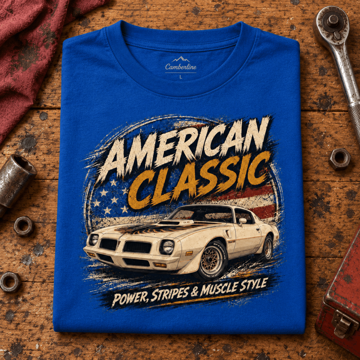 American Classic T/A 6.6 Muscle Car Graphic T-Shirt – Royal Blue, folded front hero on a worn automotive workbench – car-ts-0135