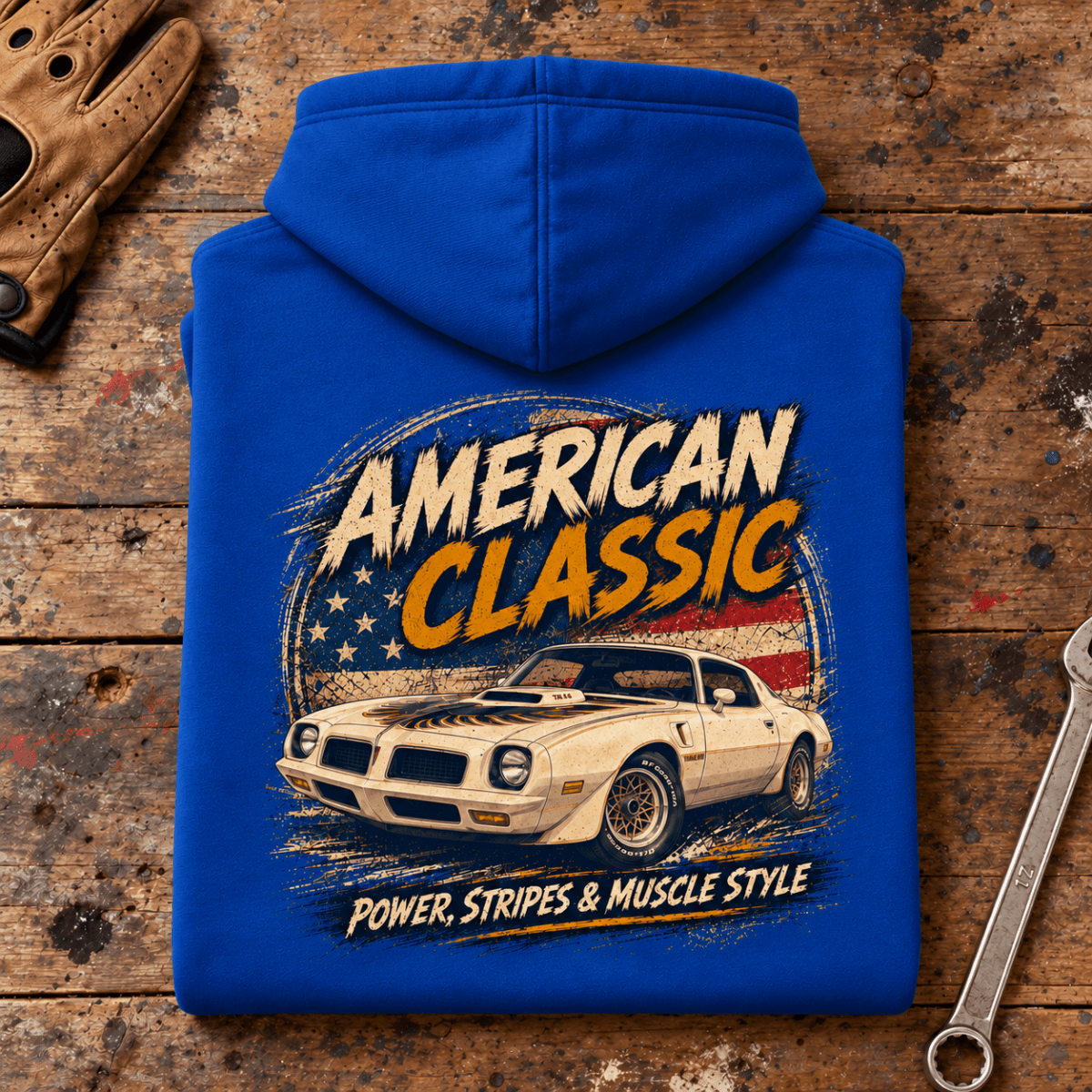 Camberline American Classic T/A 6.6 Muscle Car Graphic Hoodie in royal blue, folded back view on a workshop bench with the full graphic visible
