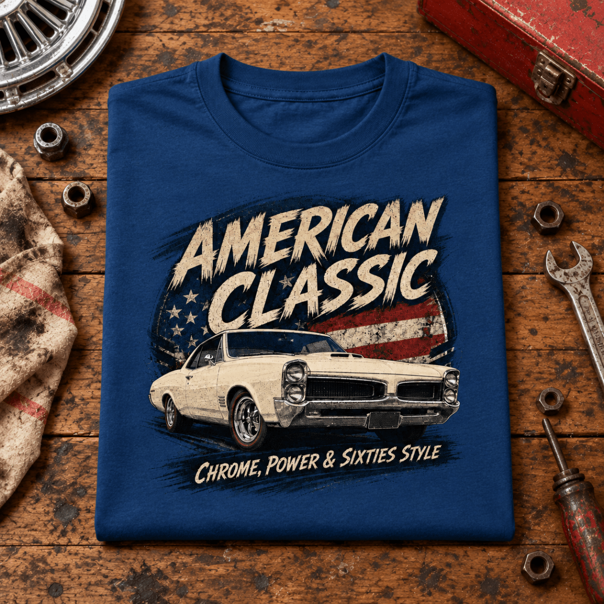 American Classic 1960s White Muscle Coupe Graphic T-Shirt – Sapphire Blue, folded front hero on a worn automotive workbench – car-ts-0144
