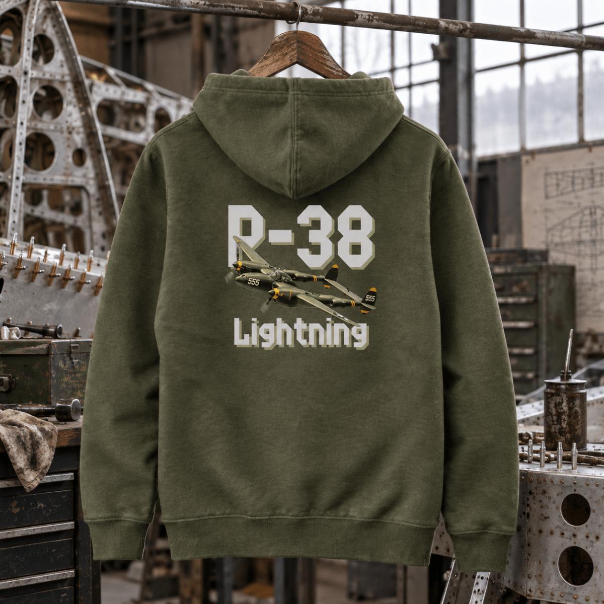 Military green P-38 Lightning hoodie in a fighter restoration bay