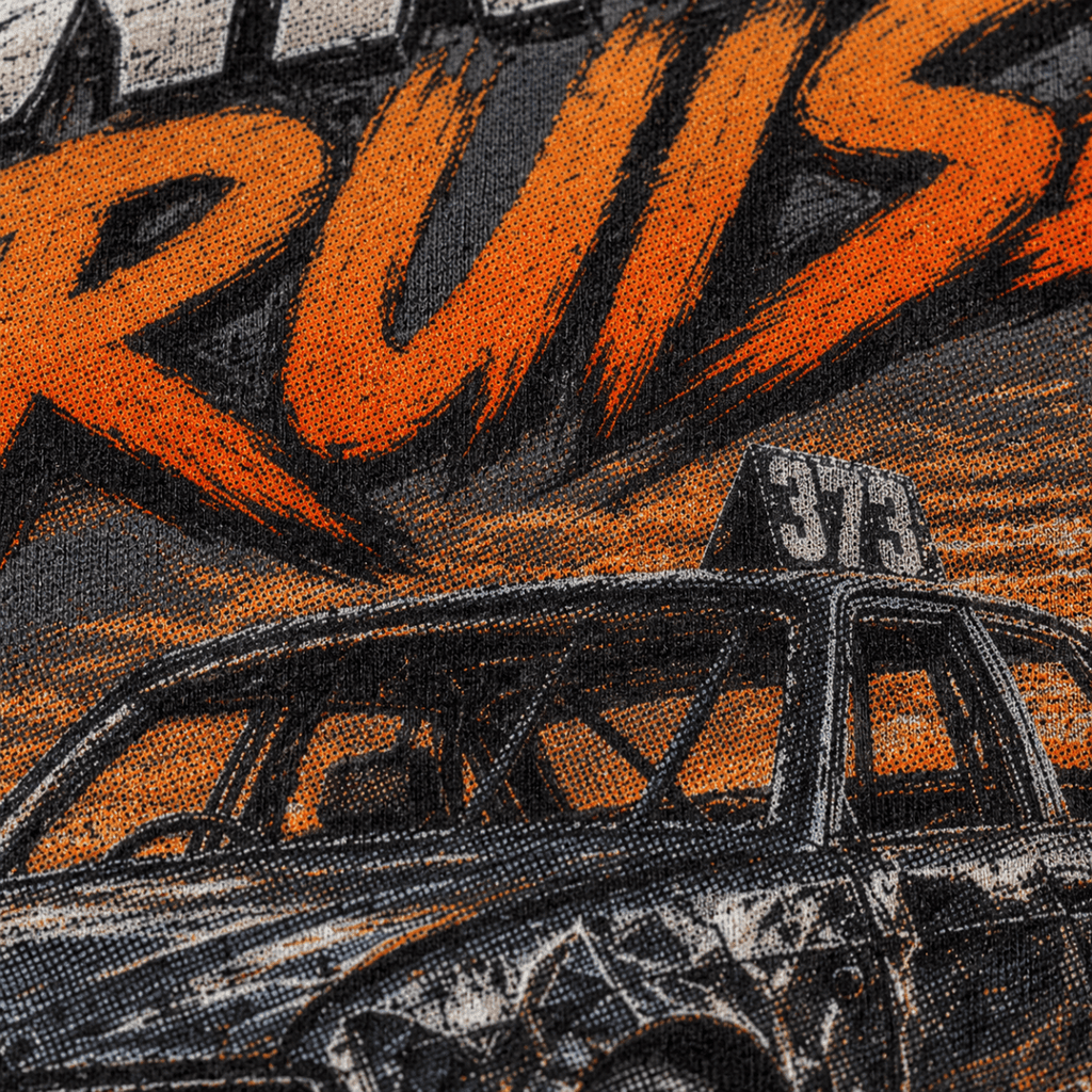 Close-up of a graphic print featuring a black race car with a roof sign reading '373' against an orange and black background with large stylized lettering above.