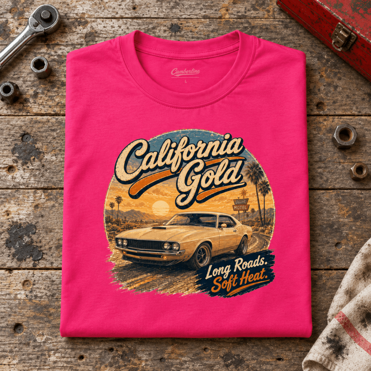 Camberline california gold classic muscle car hot pink T-shirt, folded front view on a workshop bench with the complete graphic visible.