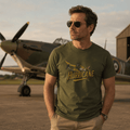 Man wearing a green t-shirt with 'Hurricane' design in front of a vintage airplane.