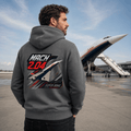 Person wearing a hoodie with an airplane design and text, standing in front of a Concorde airplane.