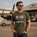 Man wearing a green t-shirt with 'P-38 Lightning' design in front of an airplane at Camberley Airfield.