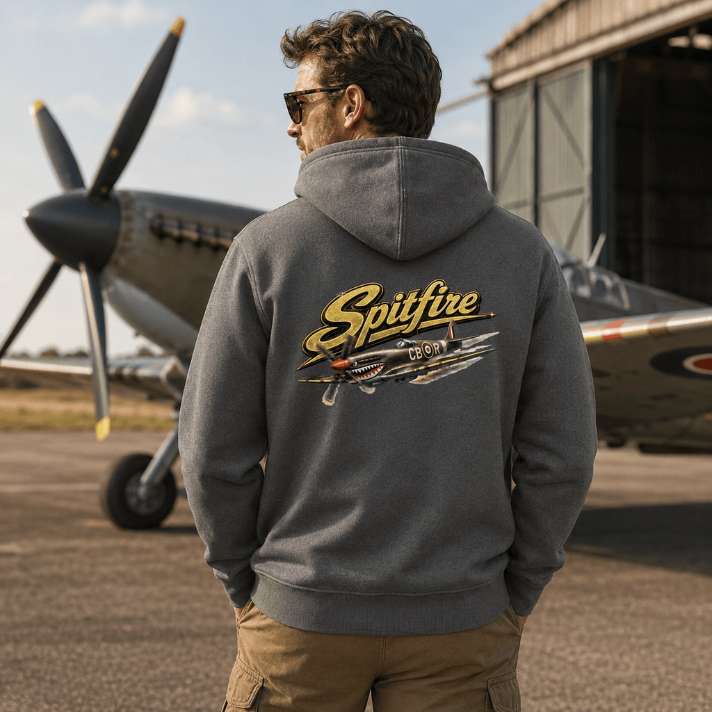 Person wearing a hoodie with 'Spitfire' design in front of a vintage airplane.