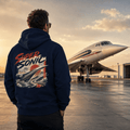 Person wearing a hoodie with 'Super Sonic' design, standing in front of a Concorde airplane at sunset.