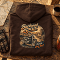 Camberline Backroad Spirit cruiser brown hoodie back print at a rustic road-stop bench