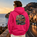 Model wearing the Camberline Cars Monte Carlo Run Classic Coupe Hoodie – Hot Pink, styled in a car culture setting