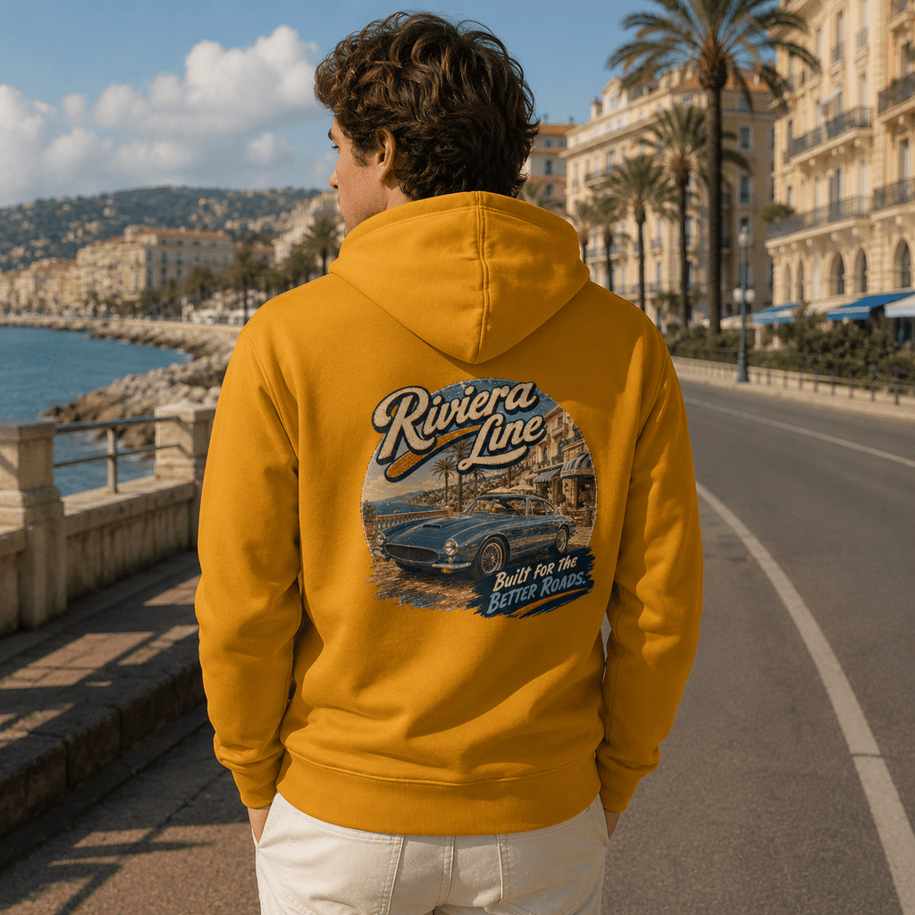 Model wearing the Camberline Cars Riviera Line Classic Coupe Hoodie – Mustard, styled in a car culture setting