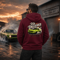 Model wearing the Camberline Cars V8 Unleashed Muscle Car Hoodie – Burgundy, styled in a car culture setting