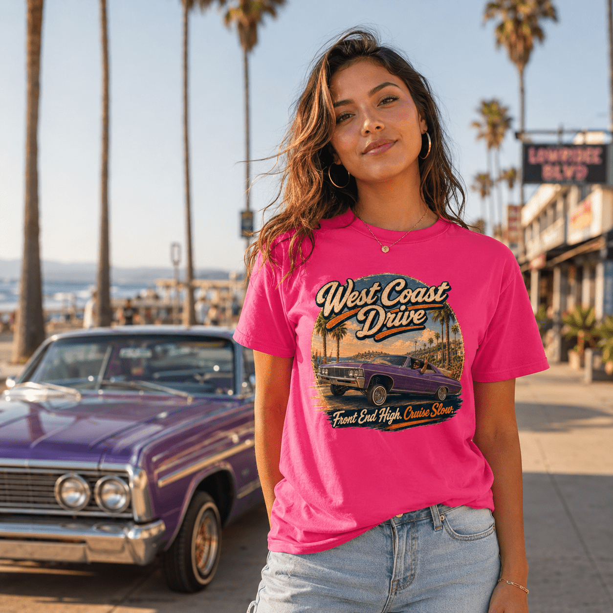 Model wearing the Camberline Cars West Coast Drive Lowrider T-Shirt – Hot Pink, showing the automotive graphic in a car culture setting