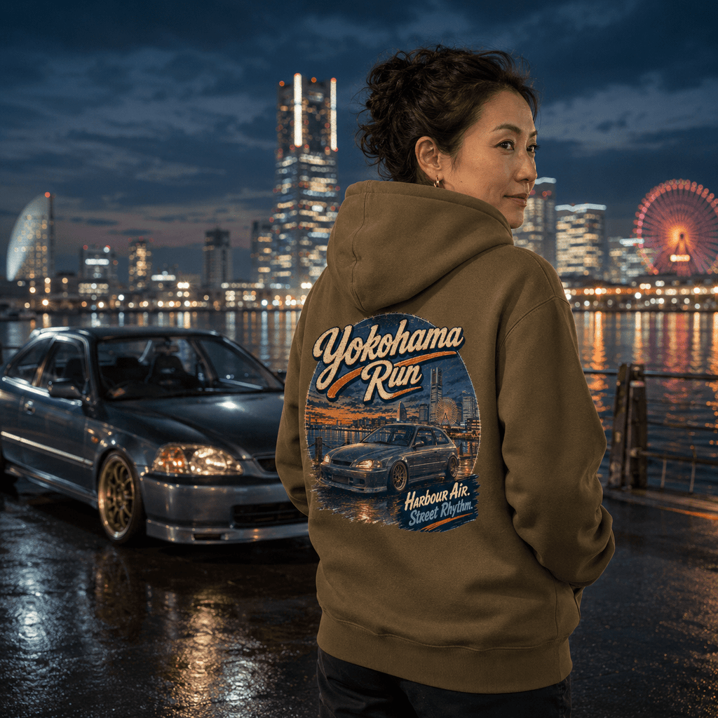 Model wearing the Camberline Cars Yokohama Run Hot Hatch Hoodie – Combat Green, showing the automotive graphic in a car culture setting