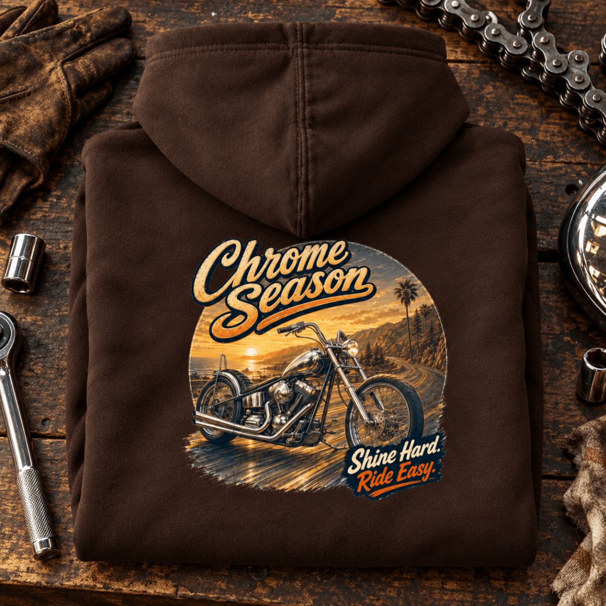 Camberline Chrome Season custom chopper brown hoodie back print on a chrome bike-builder bench