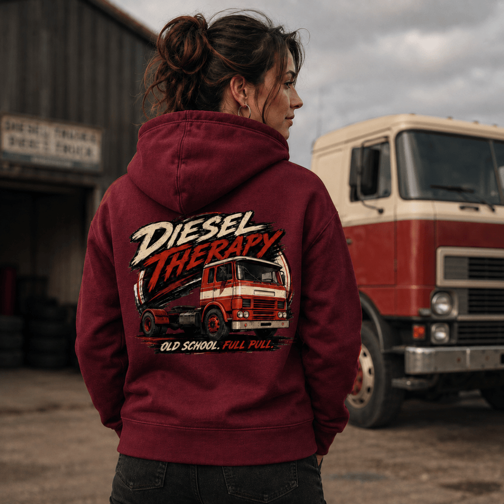 Person wearing a maroon hoodie with 'Diesel Therapy' graphic in front of a red truck.