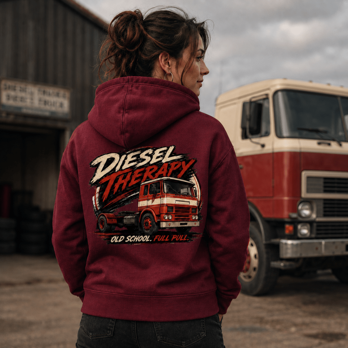 Person wearing a maroon hoodie with 'Diesel Therapy' graphic in front of a red truck.