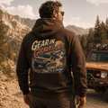 Model wearing Camberline Cars Gear In Gravel Out Dust Is A Badge Off Road 4X4 Hoodie in Hot Chocolate