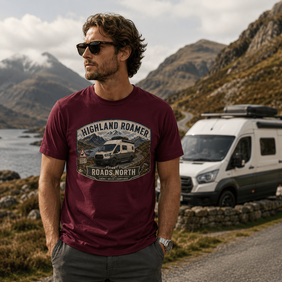 Model wearing Camberline burgundy van life t-shirt showing Highland Roamer Roads North high-roof van and Scottish loch badge on chest