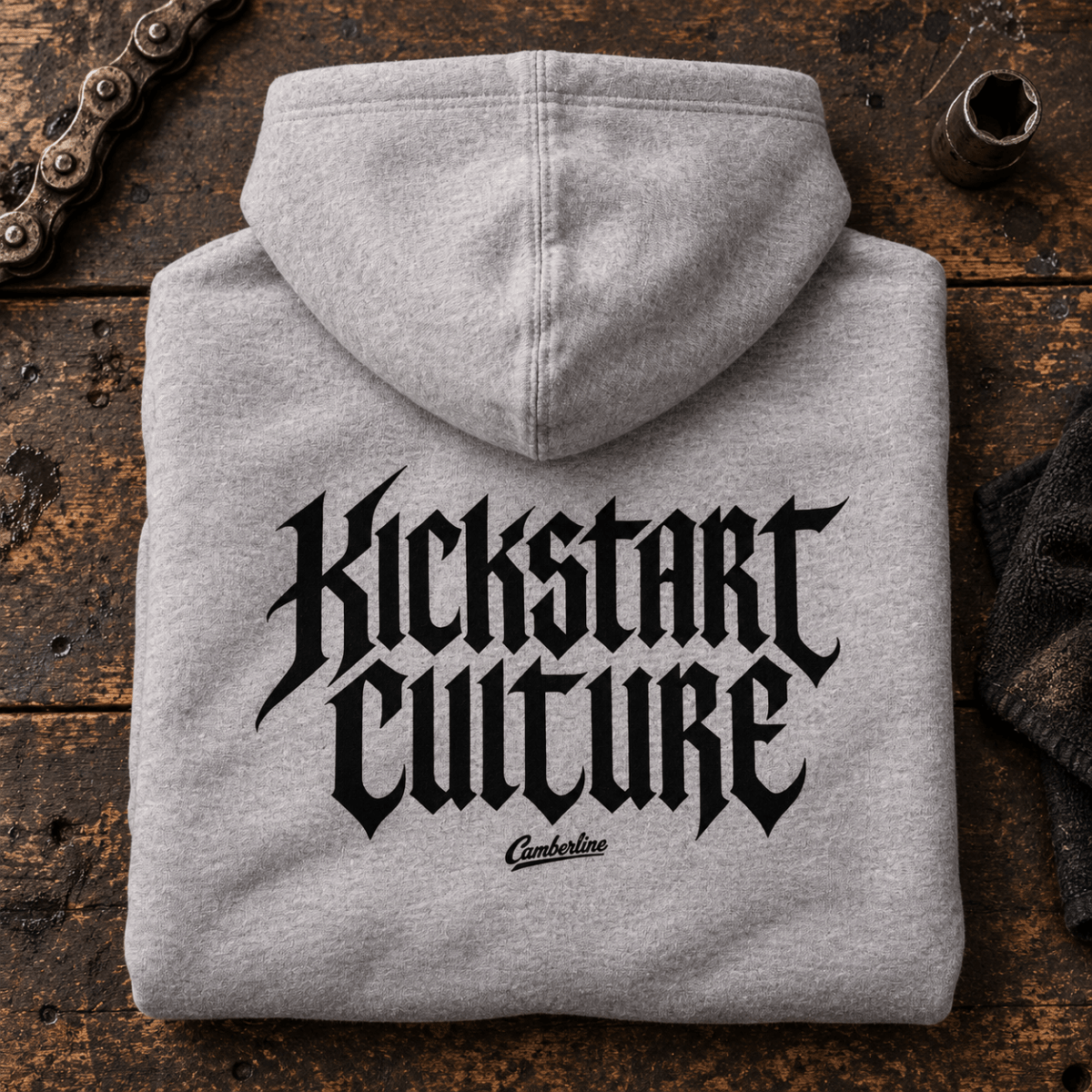 Camberline Kickstart Culture Gothic heather grey motorcycle hoodie back print on a vintage workshop bench