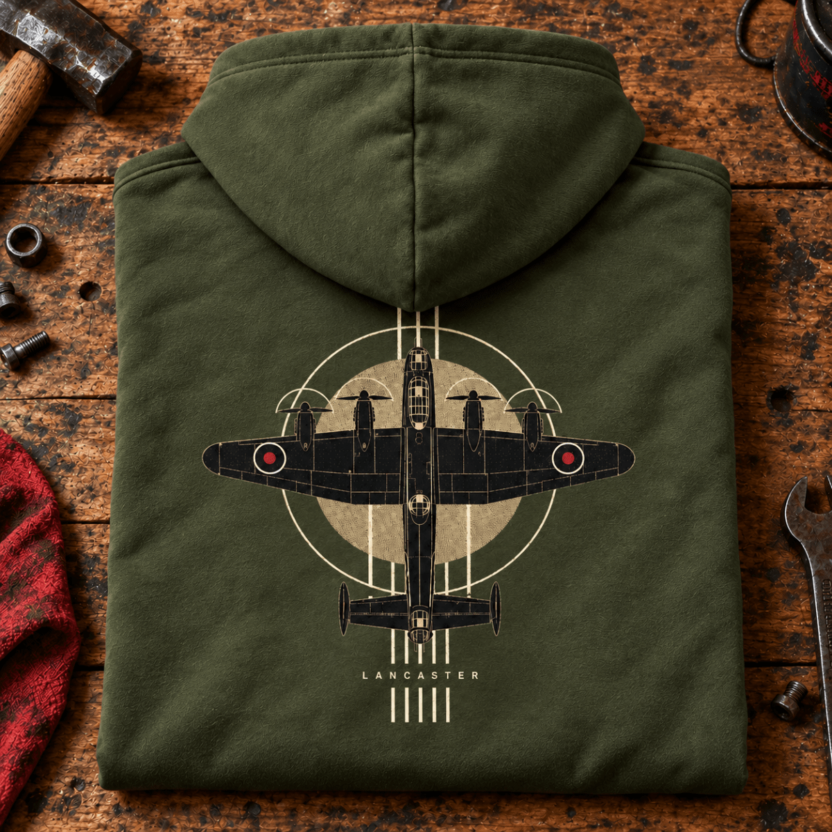 Lancaster Bomber Top View hoodie in Military Green, folded on a workshop bench, showing the back print
