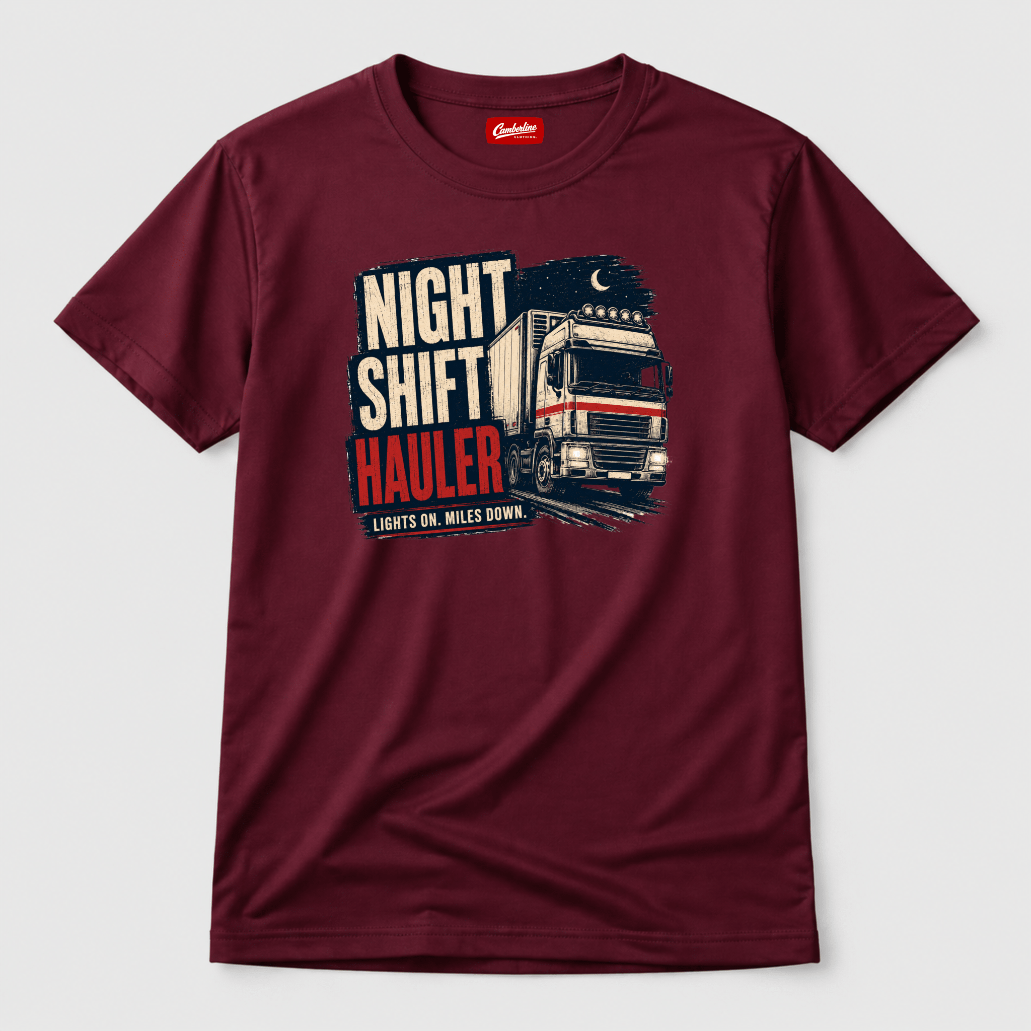 Maroon t-shirt featuring an illustration of a white lorry driving at night under a crescent moon with the text Night Shift Hauler.