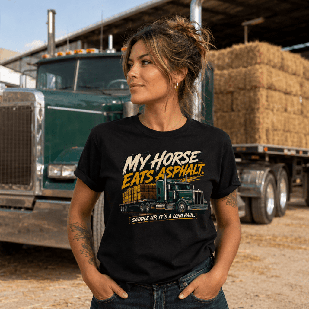 Person wearing a black t-shirt with a graphic design in front of a truck and hay bales.