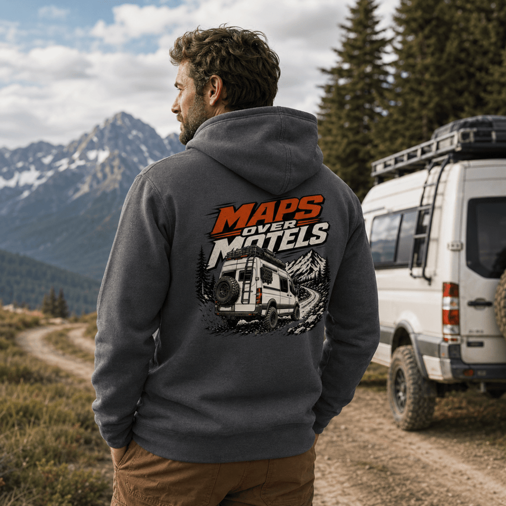 Model wearing Camberline dark heather van life hoodie showing Maps Over Motels lifted 4x4 van on mountain trail graphic on back