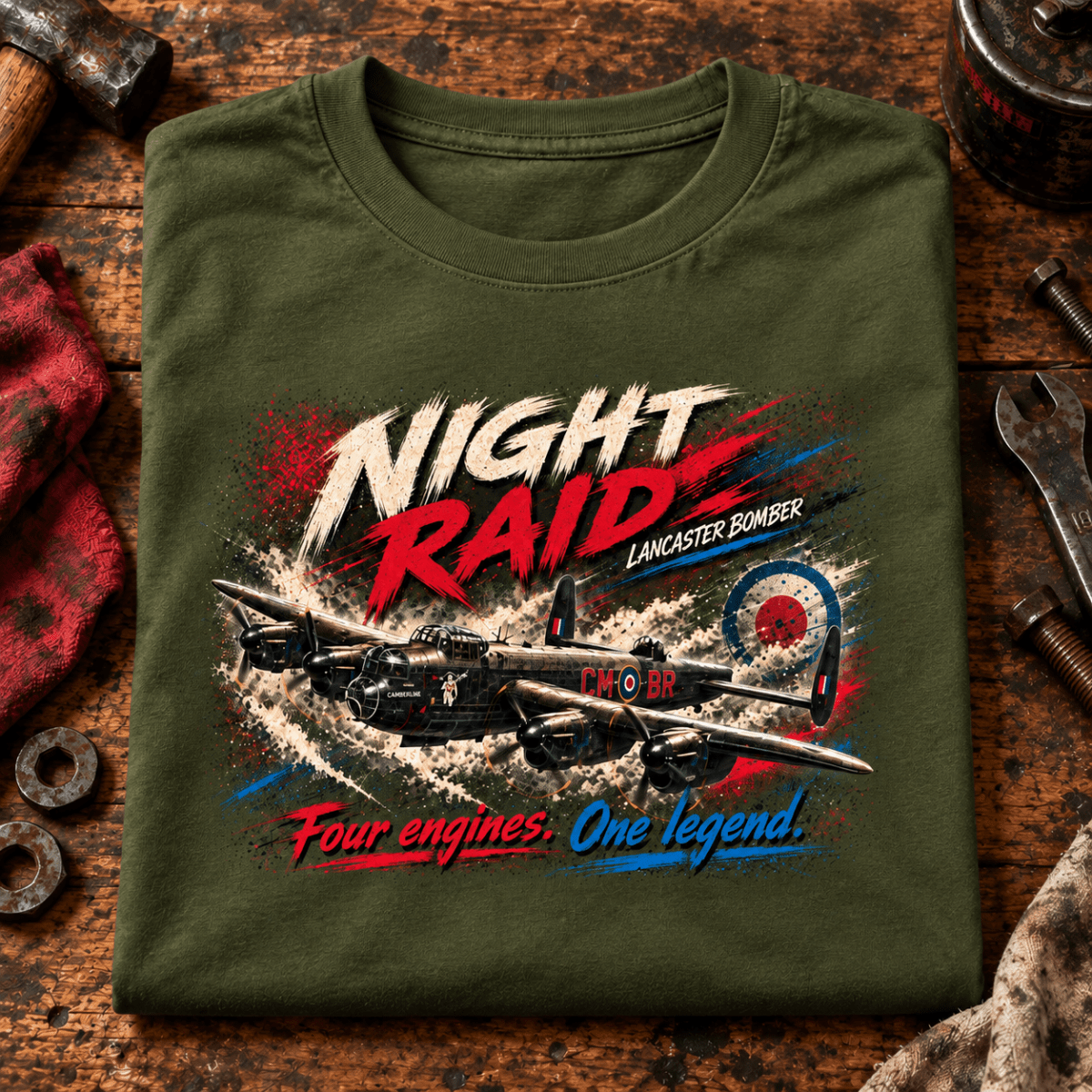 Lancaster Bomber Night Raid t-shirt in Military Green, folded on a workshop bench, showing the front print