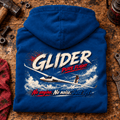 Glider Pure Flight hoodie in Sapphire Blue, folded on a workshop bench, showing the back print