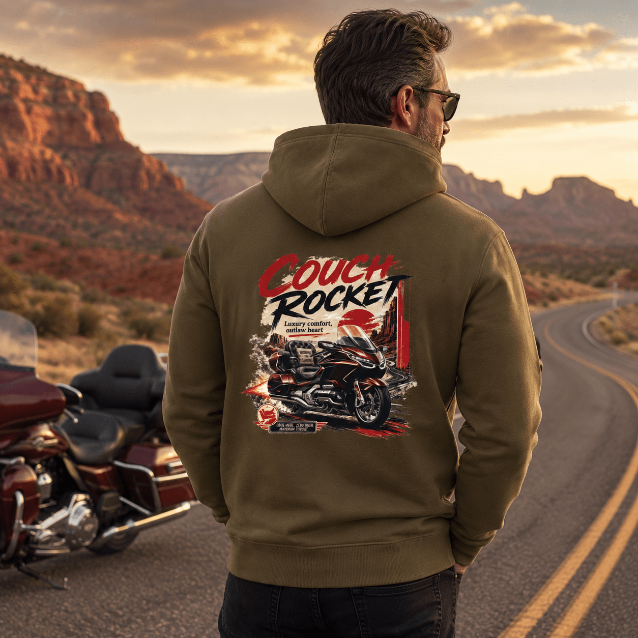 Model wearing the Camberline Riders Couch Rocket Luxury Tourer Motorcycle Hoodie – Khaki, showing the Riders back graphic in a motorcycle-inspired setting