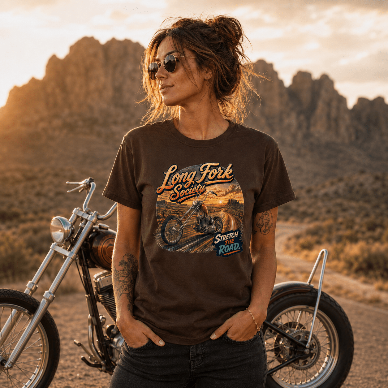 Model wearing the Camberline Riders Long Fork Society Chopper T-Shirt – Dark Chocolate, showing the Camberline Riders graphic in a motorcycle-inspired setting