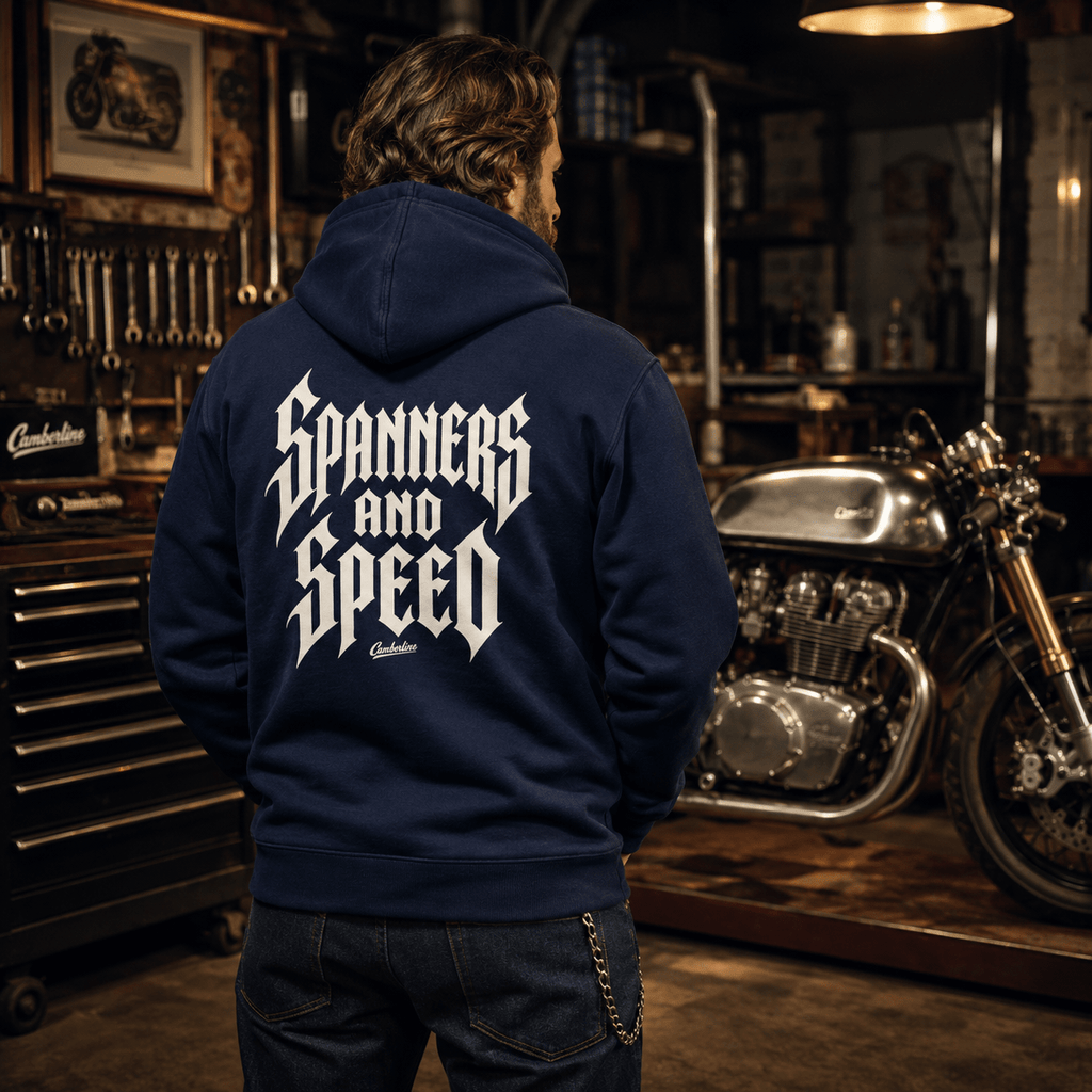 Model wearing the Camberline Riders Spanners and Speed Gothic Typography Hoodie – Navy, showing the Riders back graphic in a motorcycle-inspired setting
