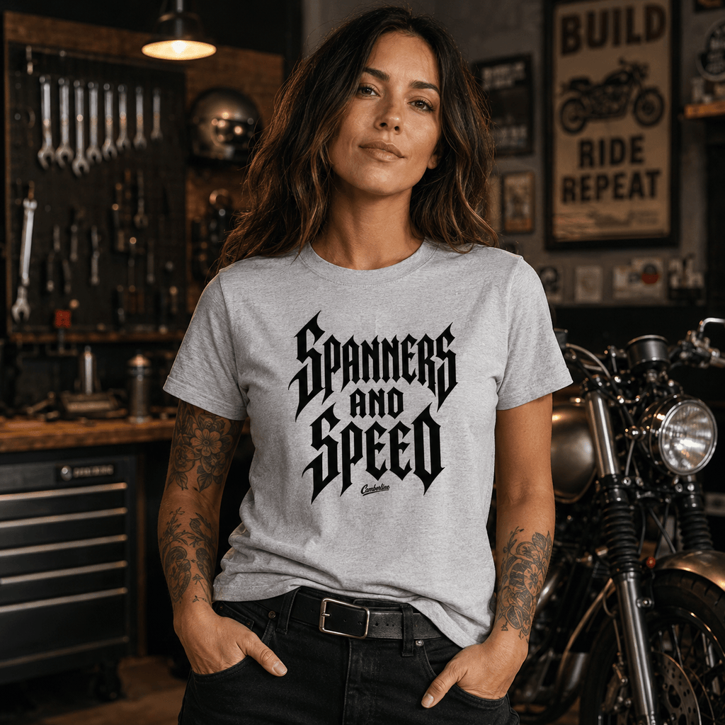 Model wearing the Camberline Riders Spanners and Speed Gothic Typography T-Shirt – Grey, showing the Riders front graphic in a motorcycle-inspired setting