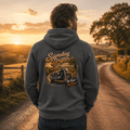 Model wearing the Camberline Riders Sunday Drifter Cruiser Motorcycle Hoodie – Charcoal, showing the Camberline Riders graphic in a motorcycle-inspired setting