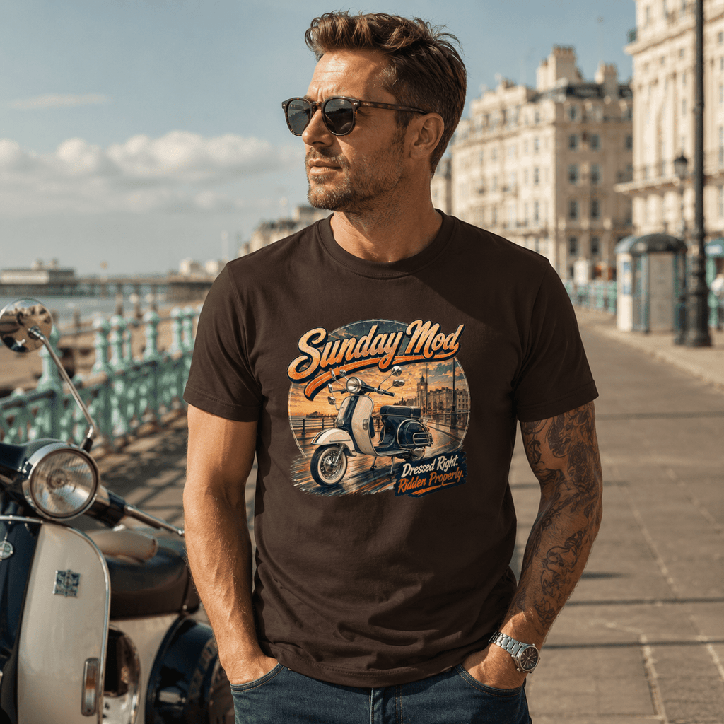 Model wearing the Camberline Riders Sunday Mod Classic Scooter T-Shirt – Dark Chocolate, showing the Camberline Riders graphic in a motorcycle-inspired setting