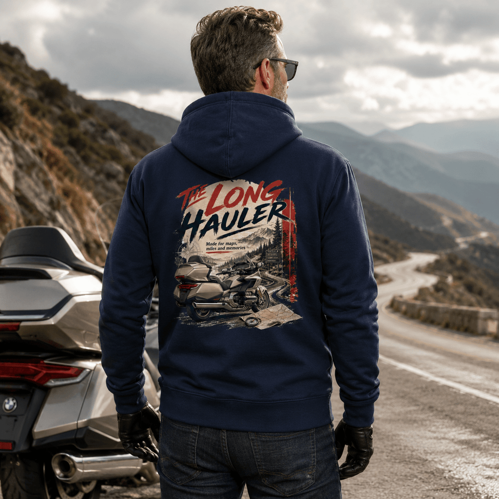 Model wearing the Camberline Riders The Long Hauler Touring Motorcycle Hoodie – Navy, showing the Riders back graphic in a motorcycle-inspired setting