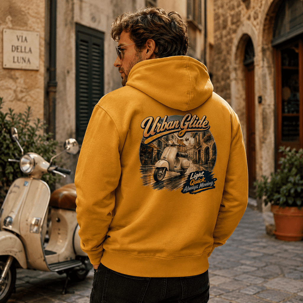 Model wearing the Camberline Riders Urban Glide Retro Scooter Hoodie – Mustard, showing the Riders back graphic in a motorcycle-inspired setting