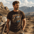Model wearing the Camberline Riders Wild Line Enduro Dirt Bike T-Shirt – Hot Chocolate, showing the Riders front graphic in a motorcycle-inspired setting