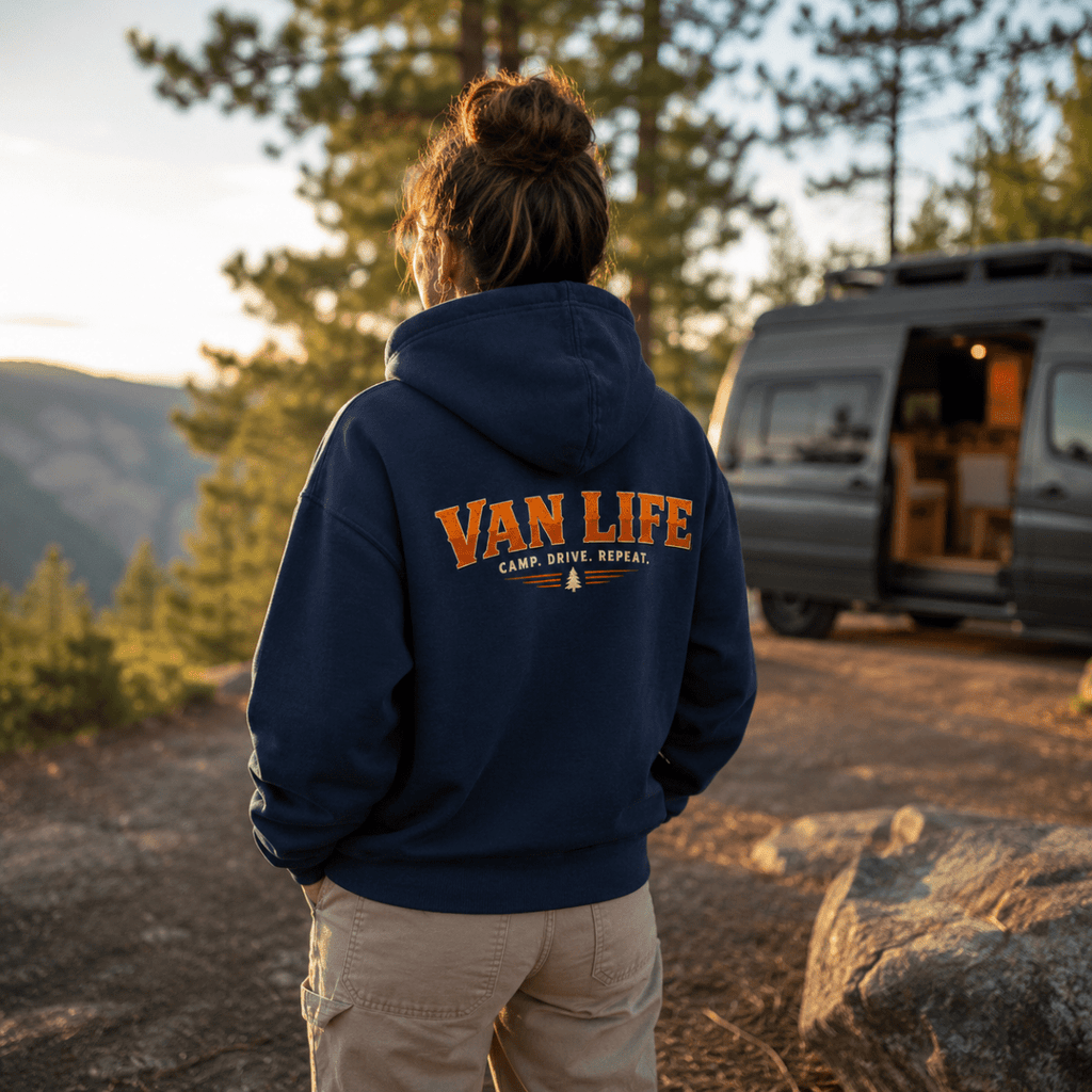 Camberline Van Life Camp Drive Repeat navy hoodie worn by female model at mountain viewpoint with converted campervan in background