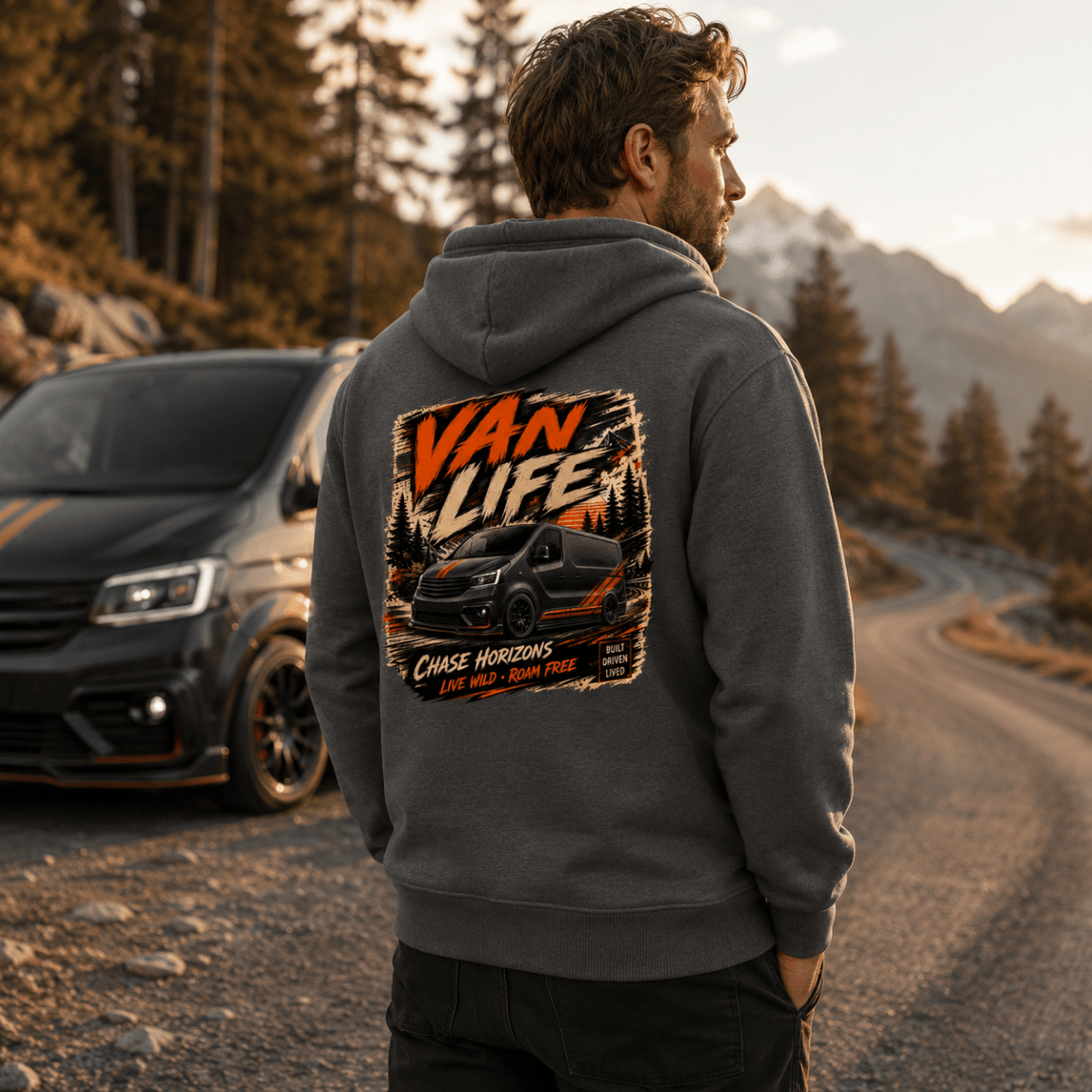 Model wearing Camberline dark heather van life hoodie showing Van Life Chase Horizons black and orange van and mountain graphic on back