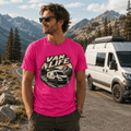 Model wearing Camberline pink van life t-shirt showing Van Life circle badge with high-roof 4x4 van on mountain road at sunset on chest