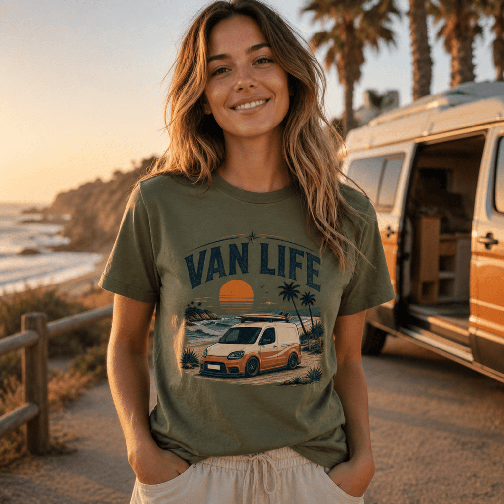 Woman wearing a 'Van Life' t-shirt by a van on a beach at sunset.