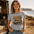 Woman wearing a 'Van Life Escape Ordinary' t-shirt by a van in a scenic outdoor setting.