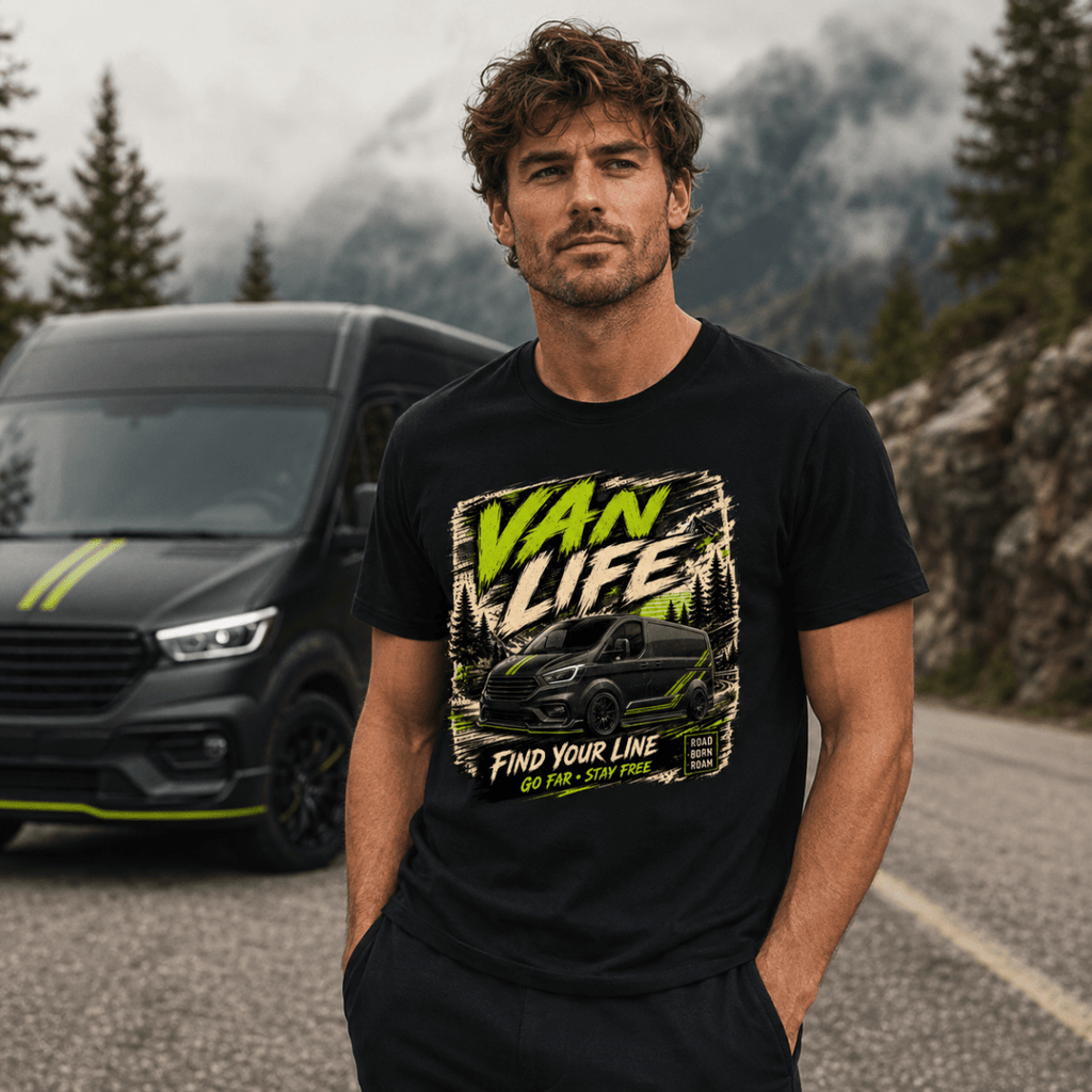 Man wearing a black t-shirt with 'Van Life' graphic in front of a black van on a mountain road.