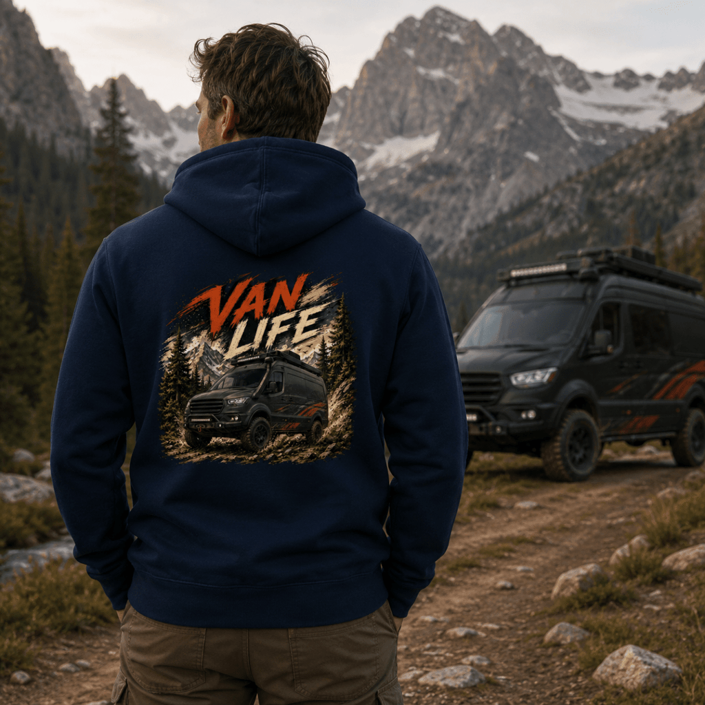 Person wearing a hoodie with 'Van Life' design in a mountainous landscape with a van.