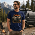 Man wearing a 'Van Life' t-shirt in a mountainous outdoor setting with a van and campfire.