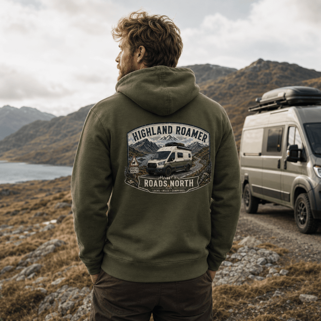 Man wearing a green hoodie with 'Highland Roamer' design, standing in a mountainous landscape with a van.
